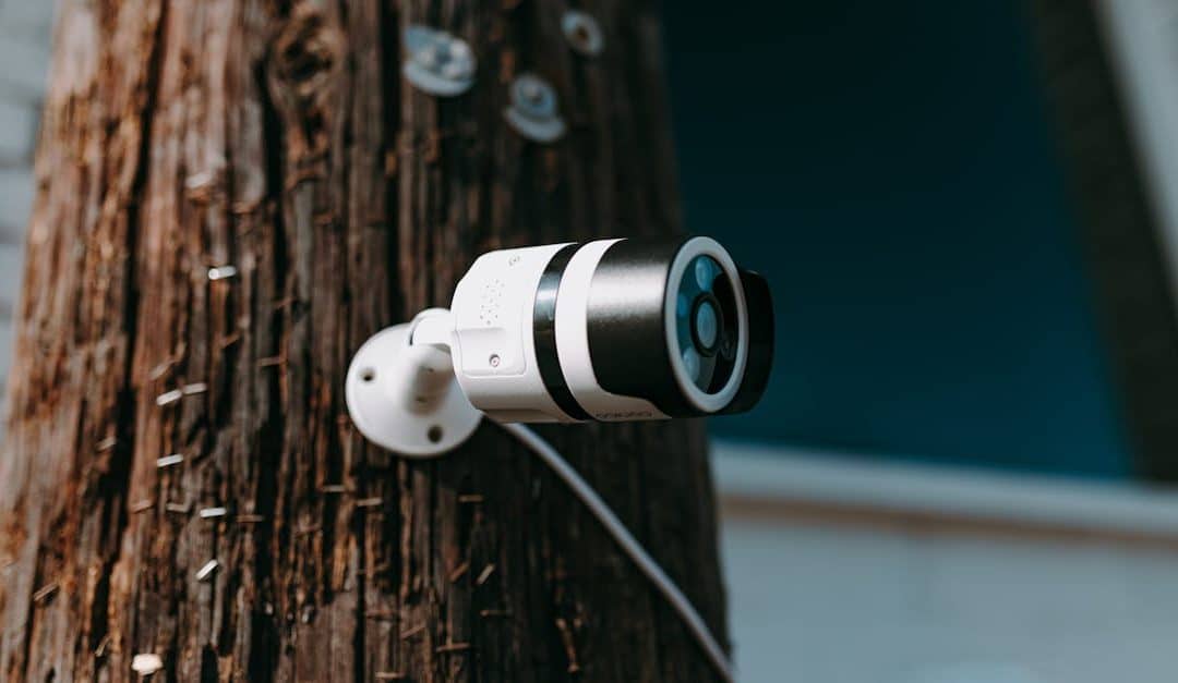 close-up-of-a-modern-security-camera-mounted-on-a-wooden-post-outdoors